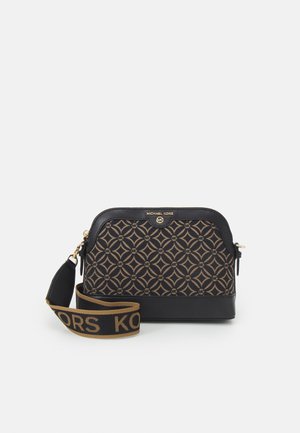 Sac bandoulière Michael Kors marron et noir avec motif géométrique, logo doré, garniture en cuir noir et bandoulière ajustable avec le nom de la marque.
