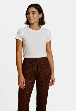 Witte T-shirt met korte mouwen gecombineerd met bruine broek met luipaardprint, voorzien van een verstelbare trekkoordtaille en een relaxed fit.