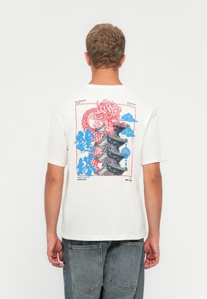 Cremefarvet bomulds T-shirt med et stort rødt og blåt dragegrafik samt pagoda-design på bagsiden. Løs pasform med korte ærmer.