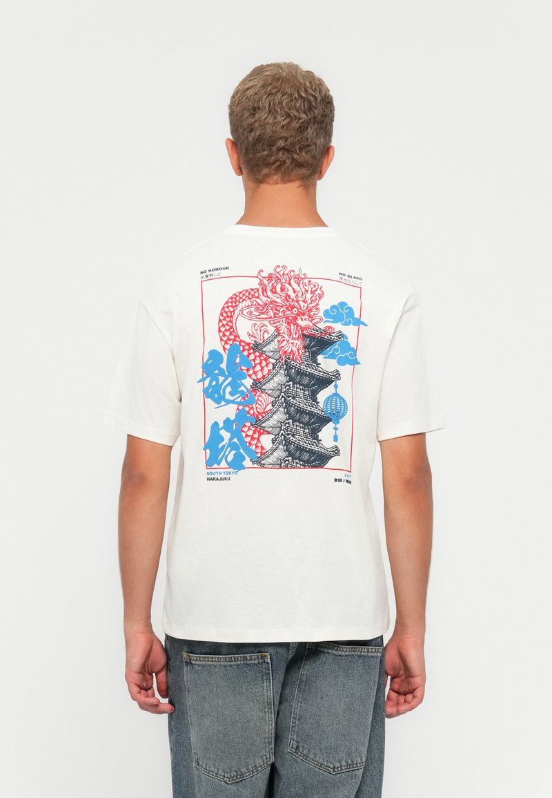 Cream-colored cotton t-shirt featuring a large red and blue dragon graphic and pagoda design on the back. Relaxed fit with short sleeves.