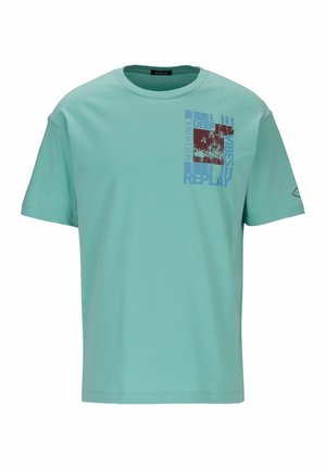 T-shirt in cotone color turchese chiaro con maniche corte, caratterizzata da una grafica rossa e blu con testo e immagini di palme sul davanti.