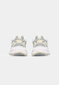 Heledatired jooksujalatsid võrgust ülaosaga, valgete ja kollaste aktsentidega, tekstureeritud tallad ning peegeldavad detailid. Tagantvaade.