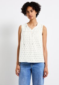 Witte, mouwloze top met een oogjesdesign en V-hals. Heeft een gatherkoord bij de hals en horizontale trimaccenten.