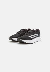 Scarpe da allenamento nere con parte superiore in rete, dettagli bianchi, design leggero, suola testurizzata e intersuola ammortizzata per il comfort.