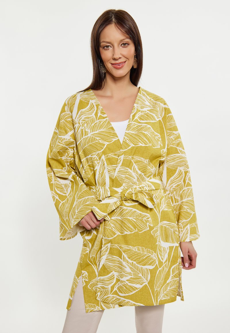 Gul kimono-stil omslag, med vita bladmönster, långa ärmar och midjebälte. Lättviktigt tyg med en avslappnad passform.