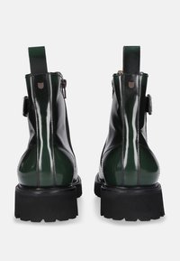 Stivaletti alla caviglia in pelle verniciata nera e verde con suola spessa, linguetta posteriore e zip laterale, caratterizzati da una finitura liscia e lucida.