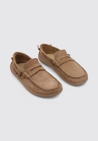 Zapatos deslizables de cuero marrón con puntera redondeada, costuras decorativas y detalles laterales acentuados. Parte superior texturizada con un acabado suave.