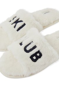 Pantofole bianche in peluche con le parole "SKI" e "CLUB" ricamate in blu navy. Tessuto morbido e peloso con design aperto sulla punta e suola piatta.