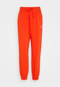 Bright orange Nike sweatpants with elastic waistband, drawstring, side pockets, and elastic cuffs on a plain white background.