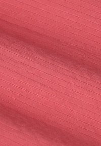 Tissu textile d'un ton corail avec de fines lignes verticales, présentant une texture lisse et un éclat subtil.