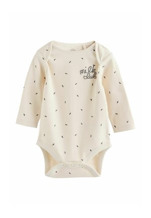 Kremo spalvos ilgos rankovės bodis su juodu taškų raštu. Papuoštas siuvinėta "milk club" užrašu ir su spaudėmis apačioje.