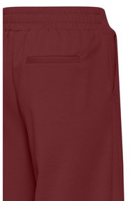 Bordeauxrode sweatpants met een gladde textuur, voorzien van een elastische tailleband en een discreet achterzakje. Eenvoudig en functioneel ontwerp.