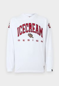 Λευκό πουκάμισο με μακριά μανίκια, με κόκκινο κείμενο "ICECREAM DESIGN" και γραφικό ενός παγωτού στο μπροστινό μέρος. Μανσέτες με ραβδώσεις και στρογγυλή λαιμόκοψη.