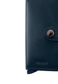 Portafoglio in pelle blu navy con una texture liscia, dotato di chiusura a bottone a pressione e marchio in rilievo. Forma rettangolare compatta.