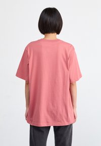 Short-sleeve, oversized t-shirt in soft rose cotton, featuring a crew neckline and relaxed fit, seen from the back.