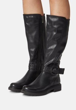 Schwarze Lederstiefel bis zum Knie mit einer strukturierten Oberfläche, ausgestattet mit einem seitlichen Reißverschluss und einem geflochtenen Gürtel-Detail um den Knöchel. Dicke Gummisohle.