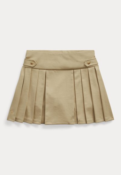 Jupe plissée beige avec pattes latérales boutonnées et large ceinture, posée à plat sur un fond blanc.