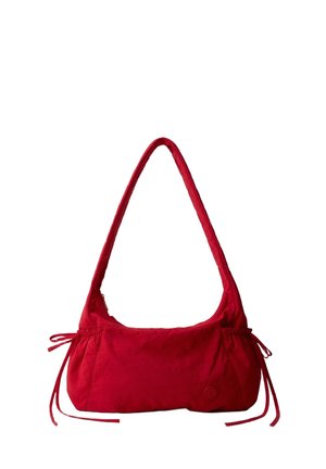 Petit sac à bandoulière rouge avec une longue sangle, côtés froncés avec des cordons noués, et un logo rond minimaliste près du coin inférieur.