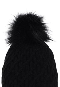 Beanie nero a maglia con un motivo a trecce testurizzate, con un morbido pom-pom nero in cima. Il materiale appare morbido e caldo.