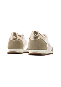 White sneakers with beige suede accents, metallic gold heel caps, and the year "1967" printed on the back. Rubber sole with textured grip.
