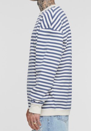 Sudadera a rayas con rayas horizontales azules y blancas, cuello redondeado y puños acanalados. Textura suave, corte relajado, diseño minimalista.