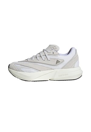 Zapatilla atlética ligera en gamuza y malla gris claro, con un upper texturizado, cordones blancos y una entresuela gruesa blanca con acentos en negro.