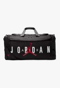 Sac de sport noir avec un grand texte blanc "JORDAN" et le logo Jumpman rouge, en tissu texturé, avec deux poignées et une bandoulière réglable.