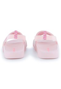 Roze rubberen sandalen met een gladde textuur, platte zool en gestreepte accenten op de banden. Open achterkant ontwerp voor gemakkelijk aan- en uittrekken.