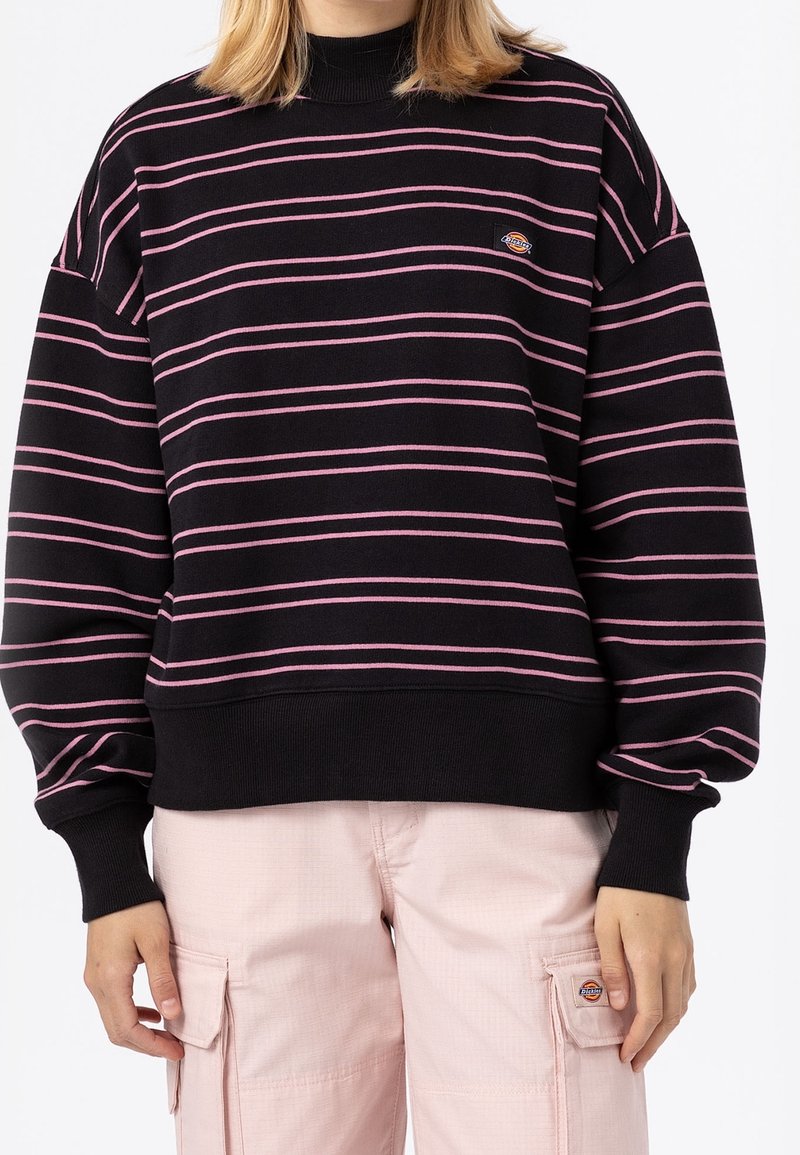 Sudadera negra con rayas horizontales rosas, cuello y puños acanalados. Lleva un pequeño logo en el pecho. Textura de tela suave.