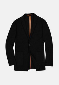 Czarna marynarka z dwoma przednimi kieszeniami, zapinana na jeden guzik, wykonana z teksturowanej tkaniny. Wnętrze podszyte pomarańczowymi paskami. Klasyczny kołnierz z wycięciem na klapę.