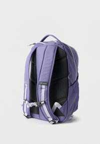 Μωβ σακίδιο πλάτης Columbia με επενδυμένη μαύρη πίσω πλευρά, ρυθμιζόμενους ιμάντες ώμου και κούμπωμα στο στήθος σε λευκό φόντο.