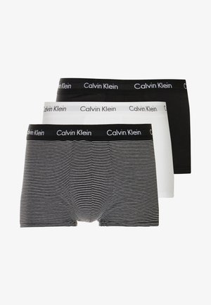 Tre paia di boxer: uno nero, uno bianco e uno nero con strisce bianche, tutti con una fascia nera con il logo "Calvin Klein".