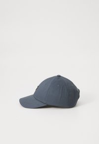 Szürke baseball sapka ívelt karimával, szövettextúrával, hat panelezett dizájnnal és egy kis sárga logóval elöl.