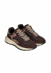 Baskets de sport marron arborant un mélange de daim et de matériaux synthétiques, une semelle texturée, des lacets en contraste et un col rembourré.