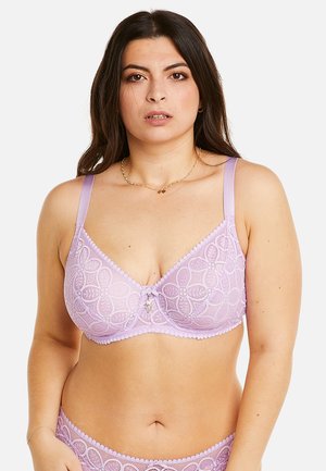 Soutien-gorge en dentelle violette avec un motif floral, des bonnets transparents et des bords à volants. Dispose de bretelles réglables et d'un petit accent décoratif au centre.