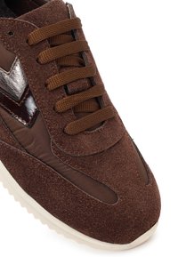 Sneaker in camoscio marrone e tessuto con lacci marroni, dettaglio a zigzag scuro sul lato e suola in gomma bianca testurizzata.