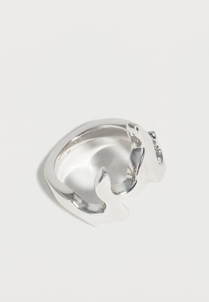 Stříbrný otevřený prsten ve tvaru dvou delfínů čelících si navzájem, s leštěným povrchem, uvnitř vyrytý s detailem značky a čistoty kovu.