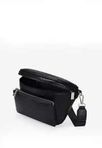Bolso de cuero negro con una superficie texturizada, que cuenta con un compartimento principal con cremallera y un bolsillo frontal, correa desmontable y herrajes plateados.