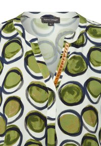 Blusa stampata con grandi motivi circolari verdi e blu navy su sfondo bianco, con scollatura a chiave e dettagli in oro testurizzato.