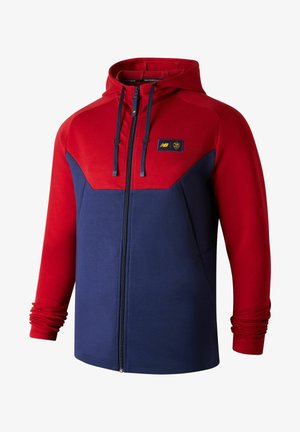 Röd och marinblå zip-up huvtröja tillverkad av mjukt tyg, med en färgblockdesign, justerbar dragsko i huvan och en logotypmärke på bröstet.