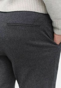 Grå skräddarsydda byxor med texturerad tyg, slim fit och en diskret bakficka med smal svart sömdekoration.