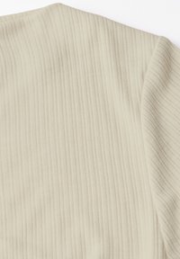 Vala beige neulottu kangas, jossa on pystysuora ribbitekstuuri. Tasainen pinta hienovaraisilla värivaihteluilla. Pehmeä ja joustava materiaali.