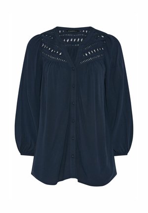 Laivastonsininen pitkähihainen pusero, jossa on nappikiinnitys edessä, liehuvat hihat ja timantinmuotoiset pitsirei'itykset yläselän ja hartioiden kohdalla.