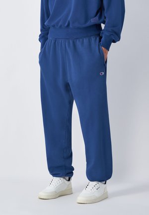 Marineblaue Sweatpants aus weichem Material mit lässigem Schnitt, elastischem Bund, seitlichen Taschen und einem kleinen Logo am linken Oberschenkel.
