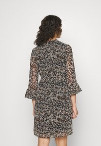 Czarna sukienka z kwiatowym nadrukiem w kremowych, beżowych i rdzawych kolorach. Posiada długie, półprzezroczyste rękawy i dopasowaną talię.