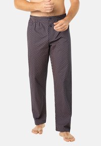Pantalons de pyjama bleu marine avec un motif géométrique en rouge et blanc, taille élastique, coupe ample, texture de tissu lisse.