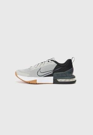 Baskets de sport basses gris et noir avec tige en mesh, coussin d'air visible dans la semelle, semelle extérieure en caoutchouc et logo Nike swoosh sur le côté.