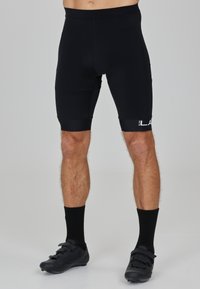Pantaloni sportivi neri con un design aderente, vita elastica e dettaglio del logo sulla gamba sinistra. Texture liscia, lunghezza a metà coscia.