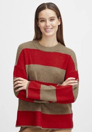 Pull en tricot avec de larges rayures rouges et taupe, col rond, coupe ample et poignets côtelés. Texture douce ; manches longues.