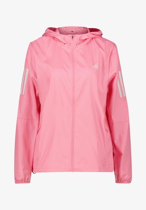 Chaqueta ligera rosa Adidas con capucha, cremallera completa en el frente, puños elásticos, bolsillos laterales y tres franjas reflectantes en ambas mangas.
